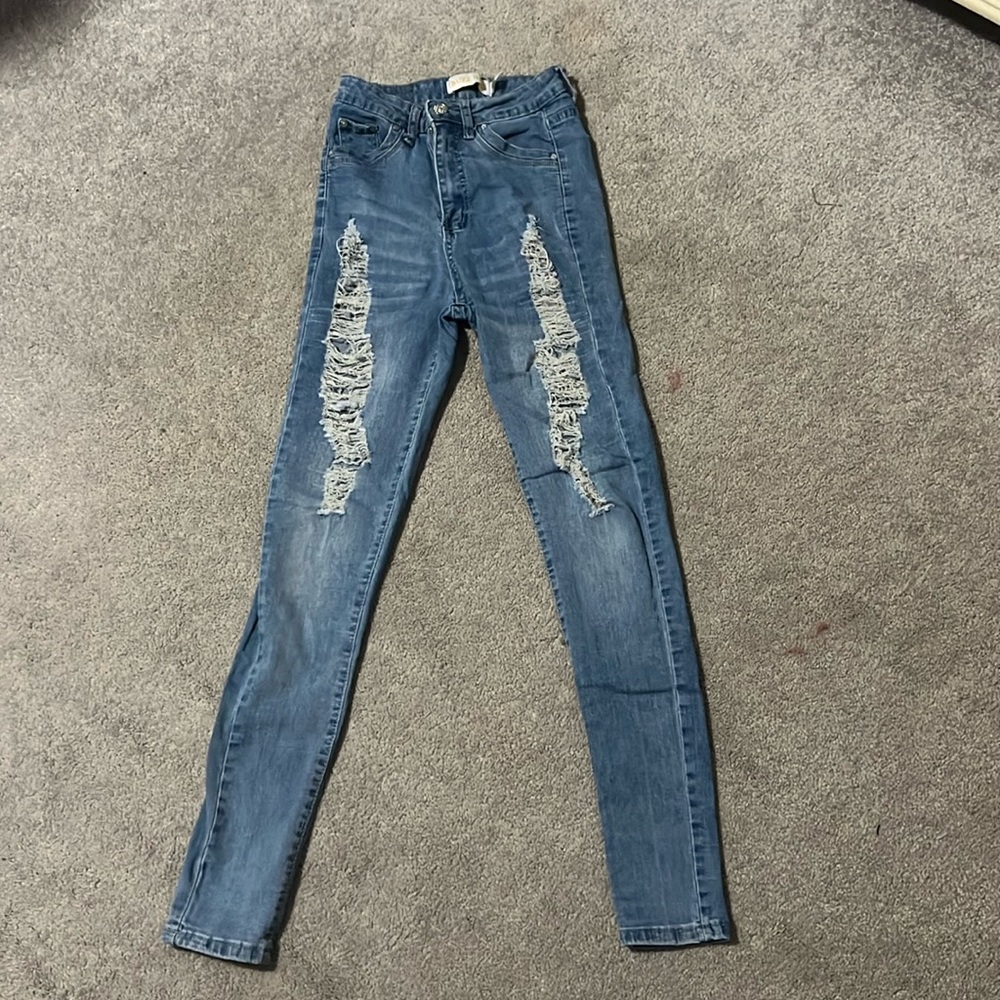 medium light wash jeans with rips down the side. skinny jeans
